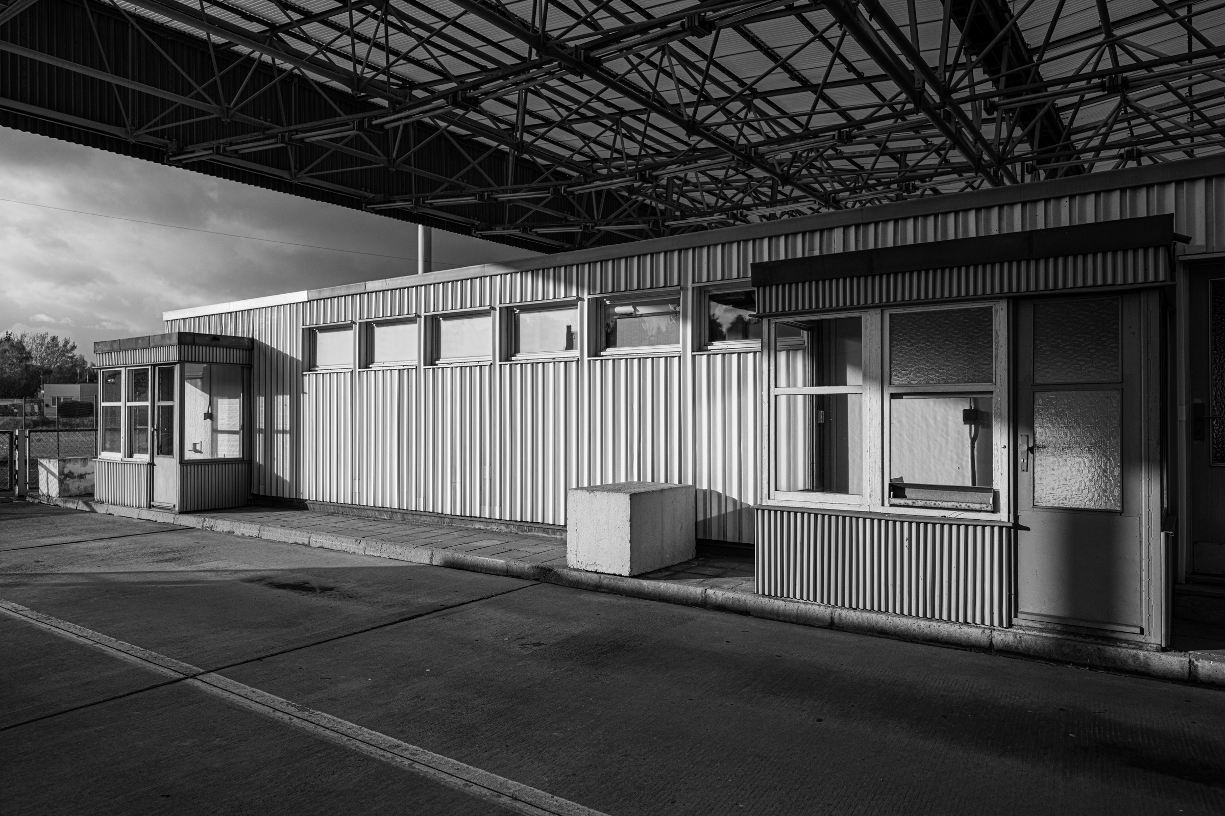 Checkpoint booths and their steel canopy in sunlight, Marienborn, 2023